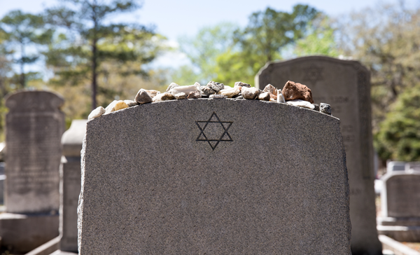 A headstone with a Jewish star and stones placed on top